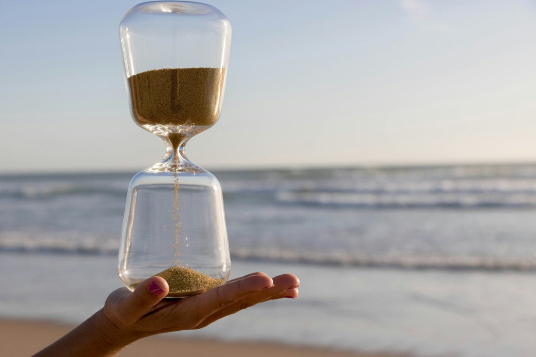 Hourglass in hand on beach